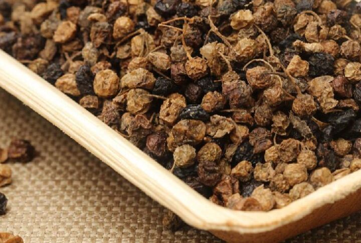 Dried black nightshade berries in tray.